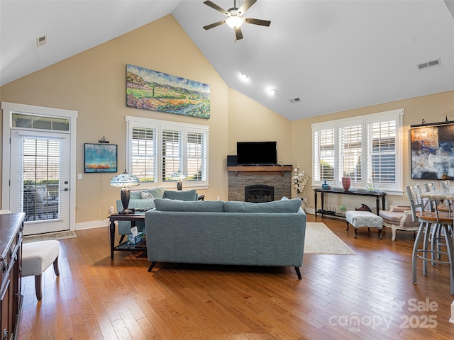 living room featuring hardwood / wood-style floors, ceiling fan, a healthy amount of sunlight, and a fireplace