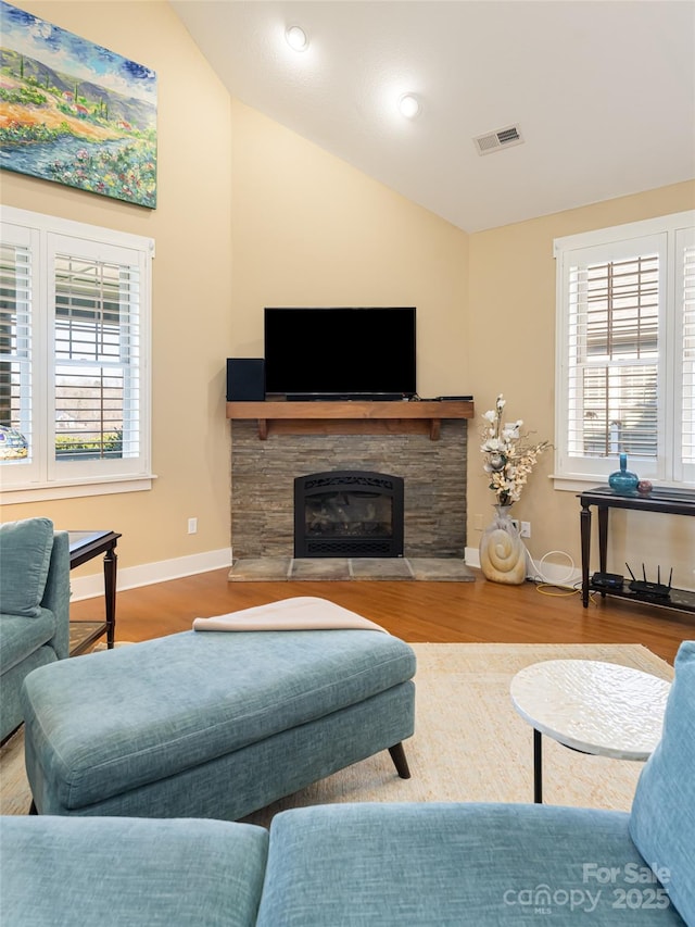 living room with a fireplace, hardwood / wood-style floors, and vaulted ceiling