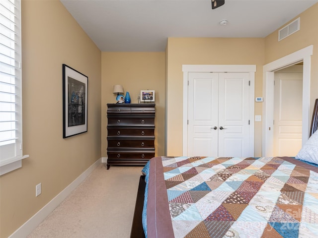 bedroom with light carpet and a closet