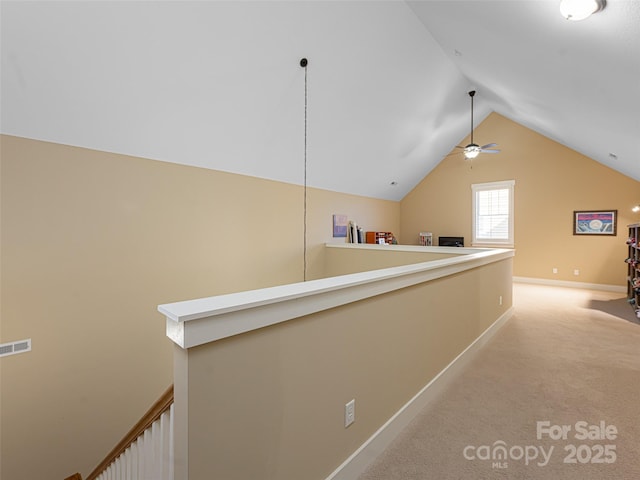 corridor with light colored carpet and vaulted ceiling