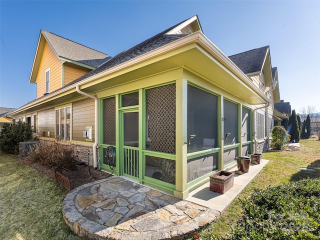 view of home's exterior featuring a sunroom and a yard