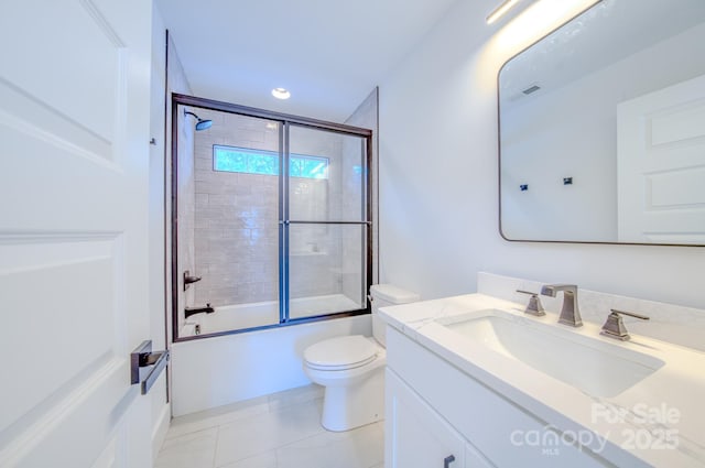 full bathroom with tile patterned floors, vanity, enclosed tub / shower combo, and toilet