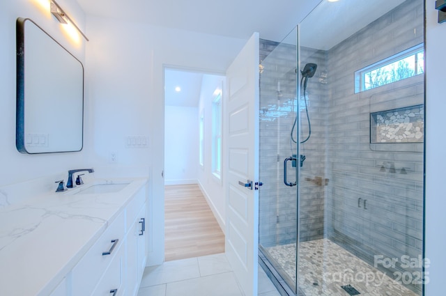 bathroom featuring tile patterned flooring, vanity, and an enclosed shower