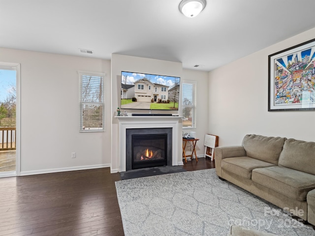 living room with plenty of natural light and dark wood-type flooring