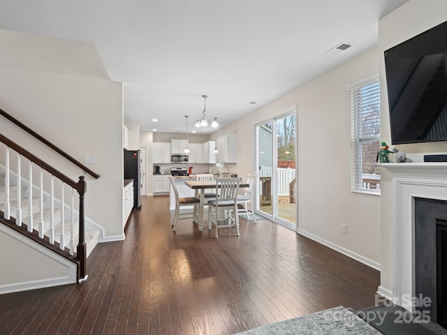 dining area with a notable chandelier and dark hardwood / wood-style flooring