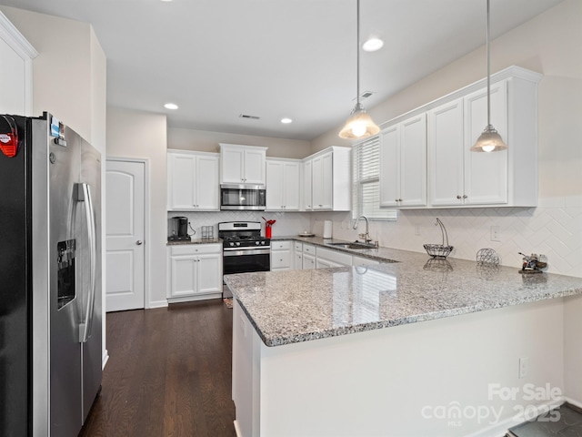 kitchen with white cabinets, kitchen peninsula, stainless steel appliances, and hanging light fixtures