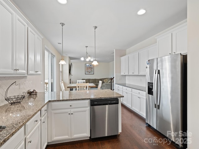 kitchen with appliances with stainless steel finishes, dark hardwood / wood-style floors, white cabinetry, and decorative light fixtures