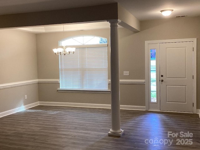 foyer entrance with a chandelier, dark hardwood / wood-style flooring, and ornate columns