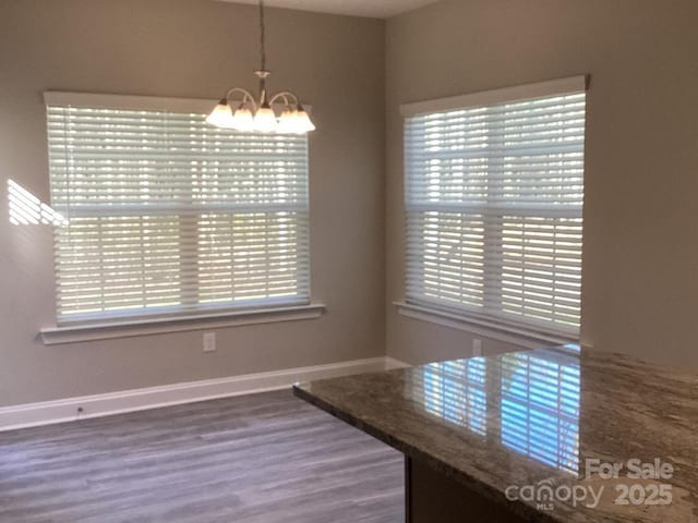 unfurnished dining area featuring hardwood / wood-style floors and a notable chandelier