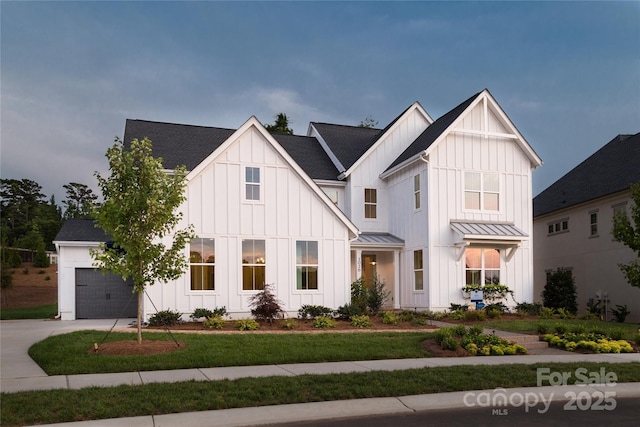 modern farmhouse style home with a front yard and a garage