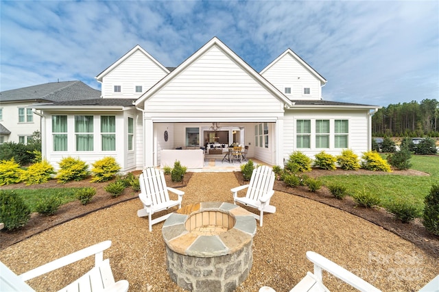 rear view of property with an outdoor fire pit and a patio