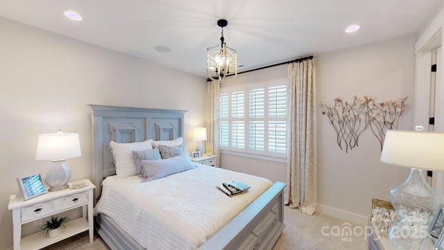 bedroom featuring an inviting chandelier and light colored carpet