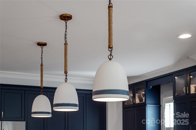 room details featuring decorative light fixtures and blue cabinetry