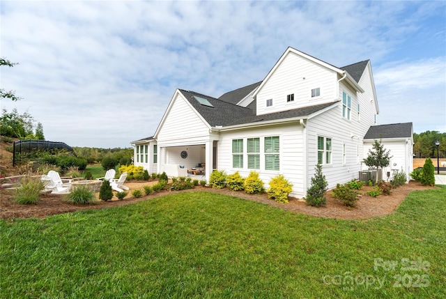 view of front of home with central AC and a front yard