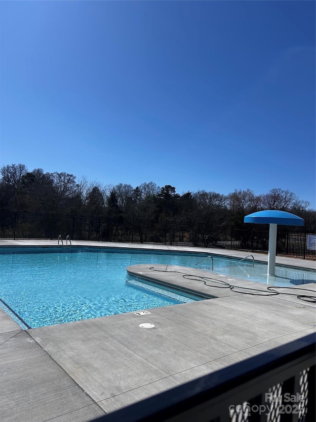 pool with fence and a patio