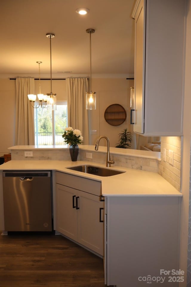 kitchen featuring a sink, light countertops, decorative backsplash, dishwasher, and pendant lighting