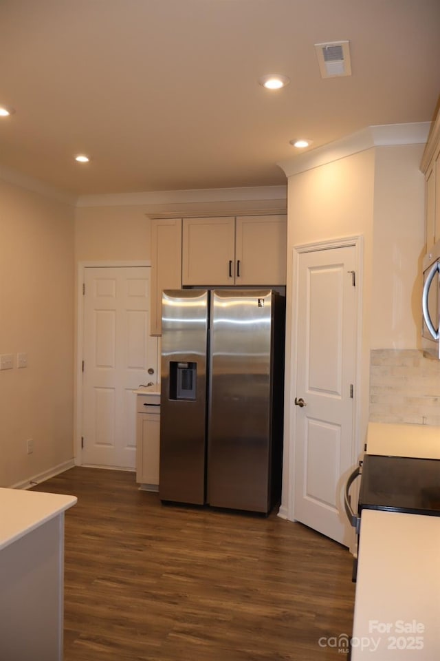 kitchen with appliances with stainless steel finishes, dark wood-style flooring, visible vents, and crown molding