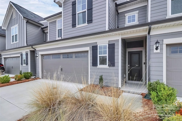 doorway to property with a garage and driveway