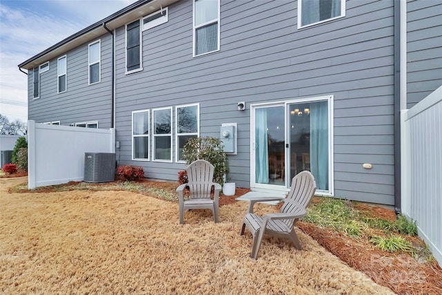 back of house featuring central air condition unit and fence