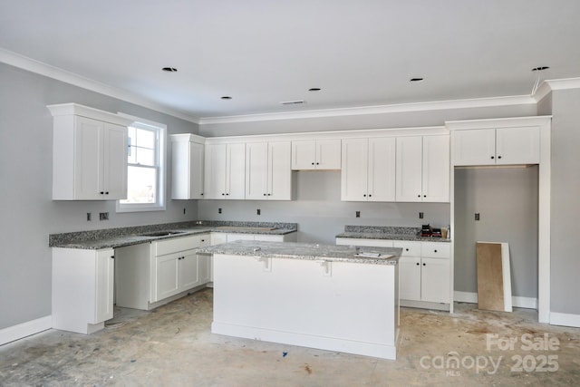 kitchen featuring a center island, ornamental molding, light stone counters, white cabinets, and sink