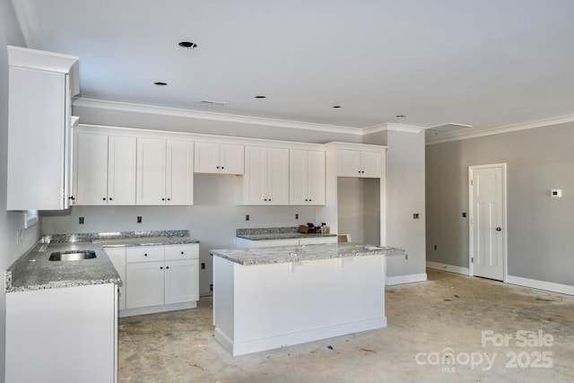 kitchen with a center island, crown molding, light stone counters, sink, and white cabinetry