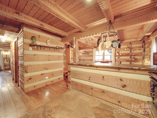 interior space featuring beamed ceiling, hardwood / wood-style flooring, wooden ceiling, and wooden walls