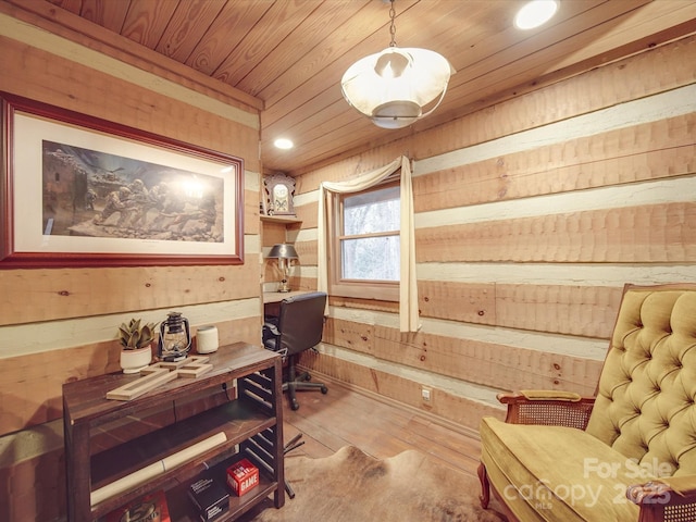 office area with light hardwood / wood-style flooring, wood ceiling, and wooden walls