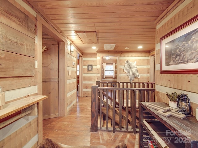 wine area featuring wooden ceiling, light wood-type flooring, and wood walls