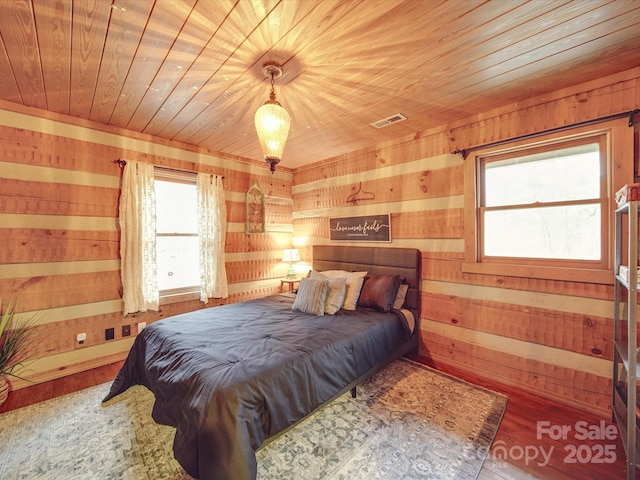 bedroom featuring wood ceiling, wooden walls, and hardwood / wood-style flooring