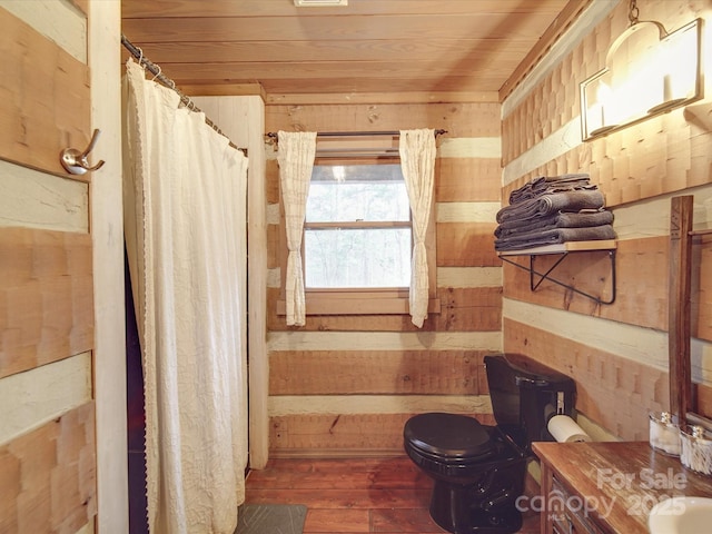 bathroom with wooden walls, wooden ceiling, and toilet