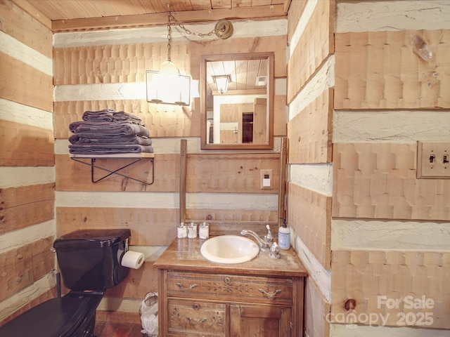 bathroom featuring vanity, wood ceiling, wooden walls, and toilet