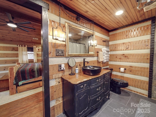 bathroom featuring wood ceiling, wooden walls, vanity, tile patterned floors, and toilet