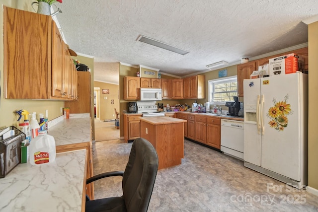 kitchen featuring white appliances, sink, a kitchen island, and a textured ceiling