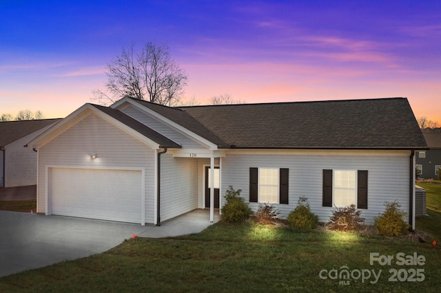 single story home with a garage and a yard