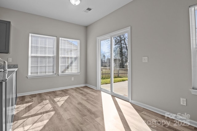 unfurnished dining area with light wood-type flooring