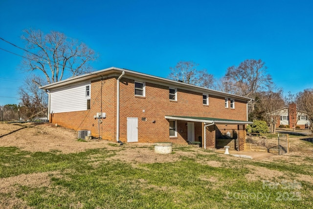 rear view of property with a yard and central AC