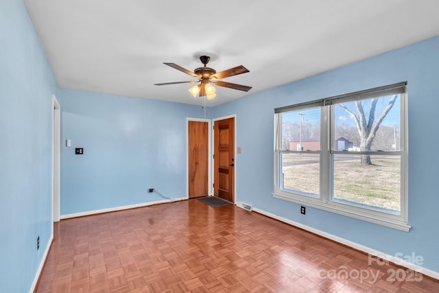 spare room featuring parquet floors and ceiling fan