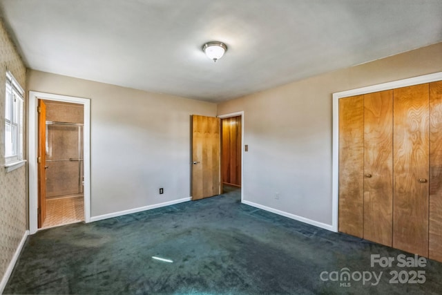 unfurnished bedroom featuring a closet and dark colored carpet