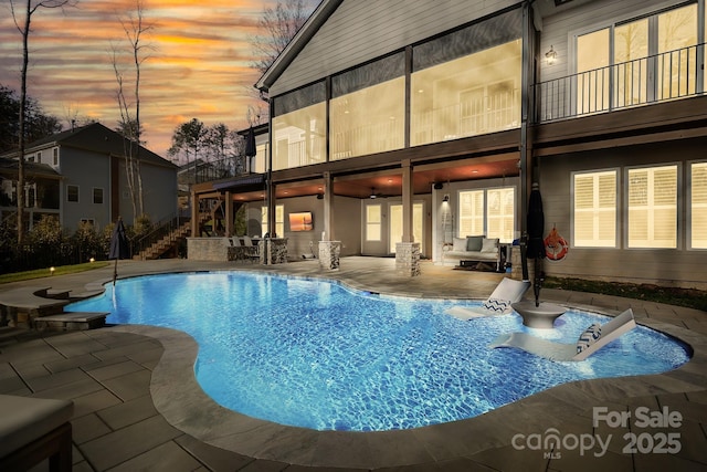 pool at dusk with a patio