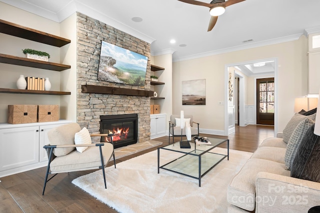 living room featuring built in shelves, light hardwood / wood-style floors, and ornamental molding