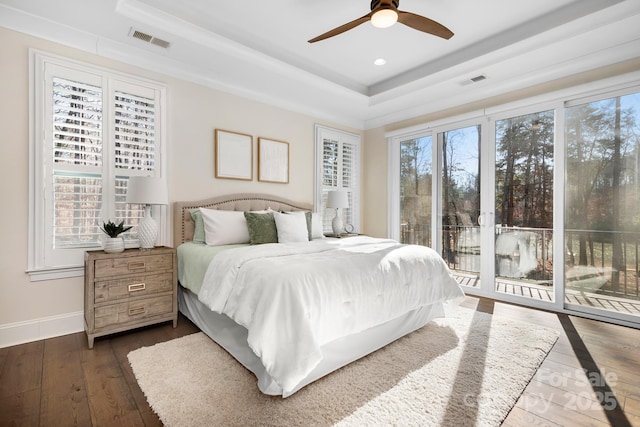 bedroom with a tray ceiling, access to exterior, ceiling fan, and dark hardwood / wood-style floors