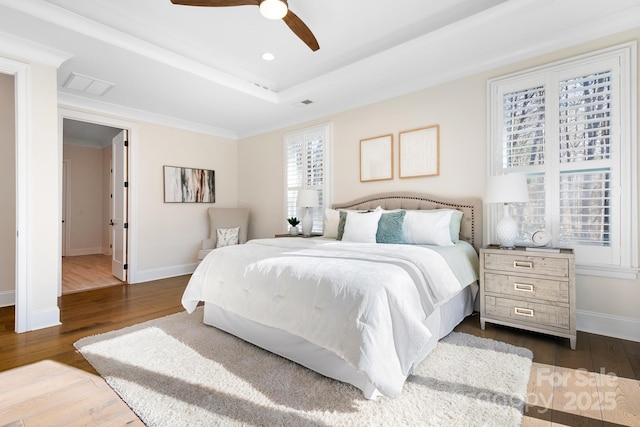 bedroom with a raised ceiling, ceiling fan, and dark hardwood / wood-style floors