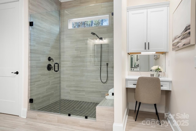 bathroom with hardwood / wood-style floors and a shower with shower door