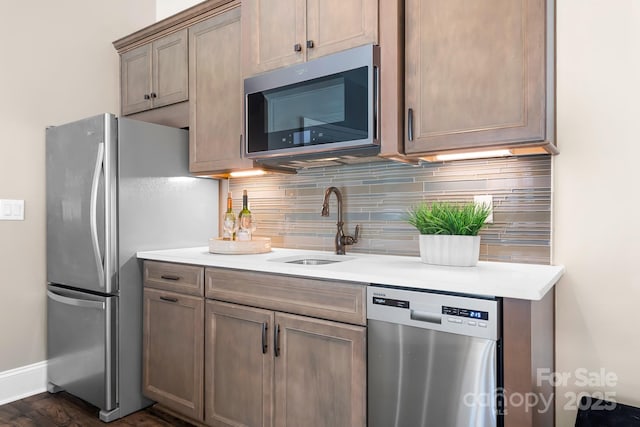 kitchen featuring decorative backsplash, stainless steel appliances, dark hardwood / wood-style floors, and sink