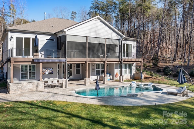 rear view of house featuring a sunroom, a yard, and a patio