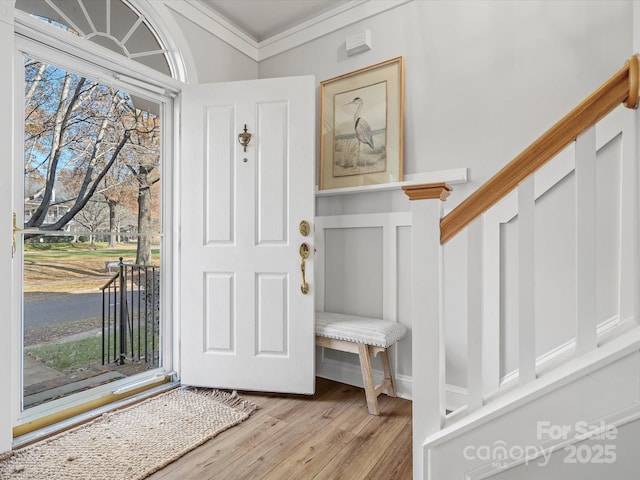 entryway with light hardwood / wood-style floors and ornamental molding