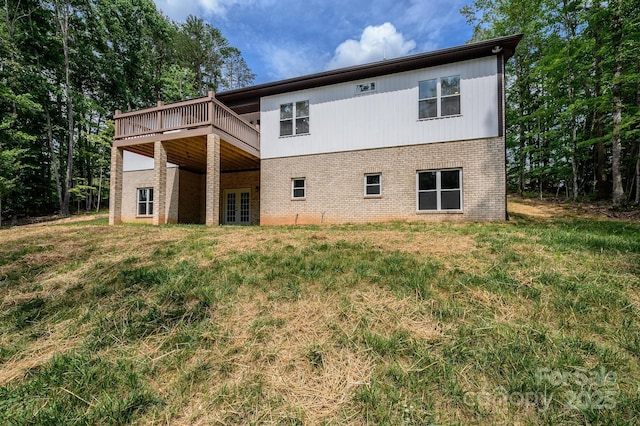 back of property featuring a lawn and a deck