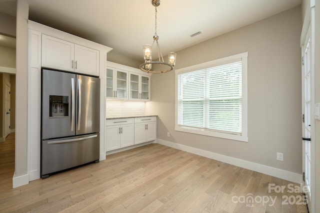 kitchen featuring tasteful backsplash, pendant lighting, light hardwood / wood-style flooring, white cabinets, and stainless steel fridge with ice dispenser