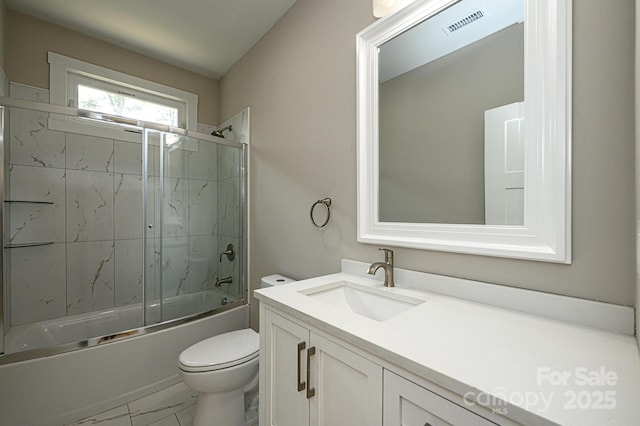 full bathroom featuring toilet, combined bath / shower with glass door, and vanity