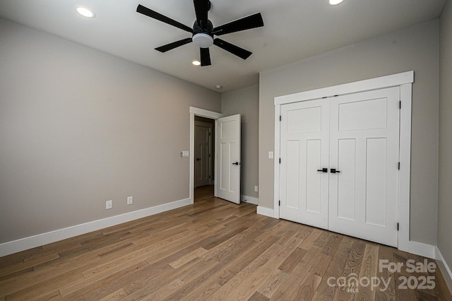 unfurnished bedroom with ceiling fan, a closet, and light hardwood / wood-style floors